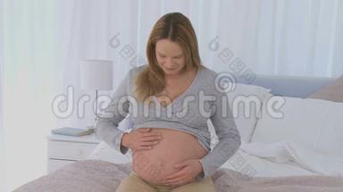 孕妇抚摸她的腹部